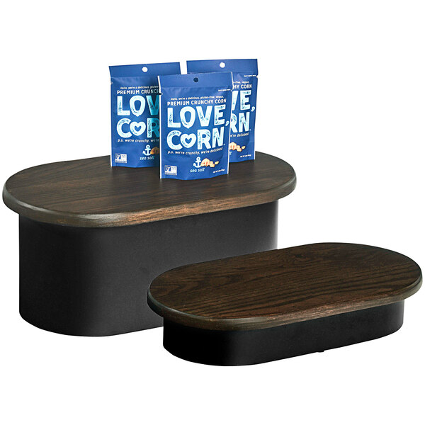 A wooden oval display riser with a blue bag on top.