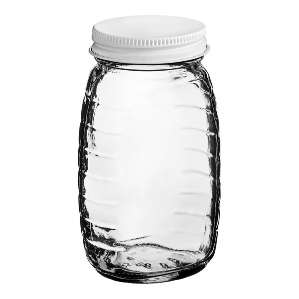 A clear Classic Queenline glass honey jar with a white metal lid.