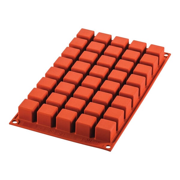 A red Silikomart silicone mold with square compartments.