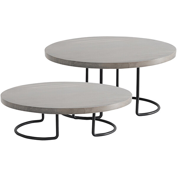 A Cal-Mil round pine display riser with a grey and black finish on a round table with metal legs.
