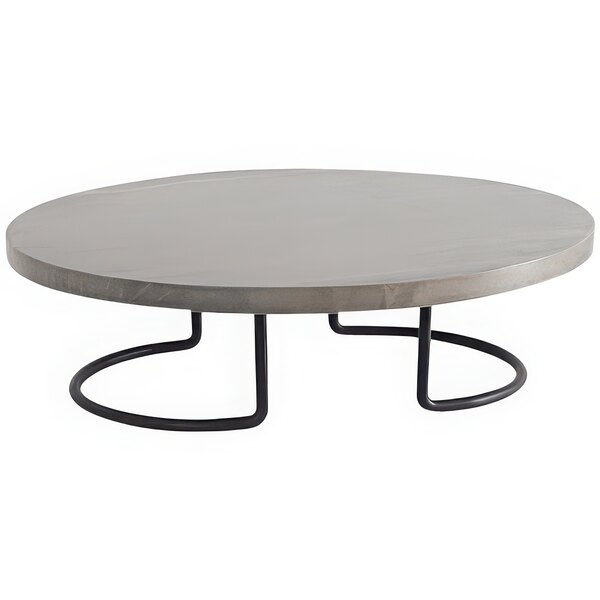 A Cal-Mil round black and gray pine display riser on a round concrete table with metal legs.