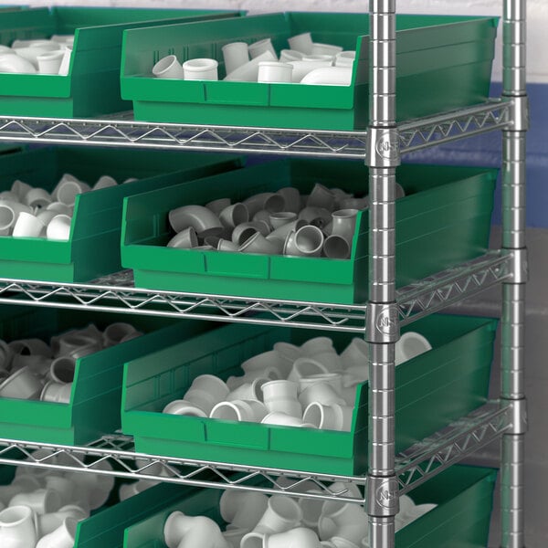 A shelf with Regency green bins filled with white objects.