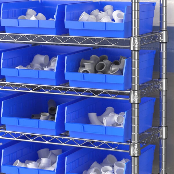 A metal shelving unit with blue Regency shelf bins holding white plastic fittings.