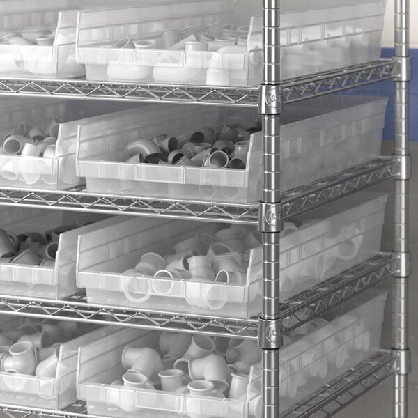 A metal shelving unit with Regency Clear plastic shelf bins.
