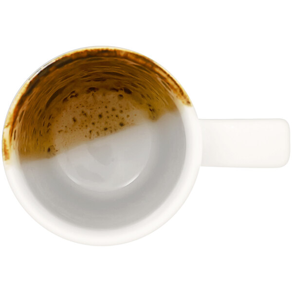 A RAK Porcelain brown mug filled with coffee on a white surface.