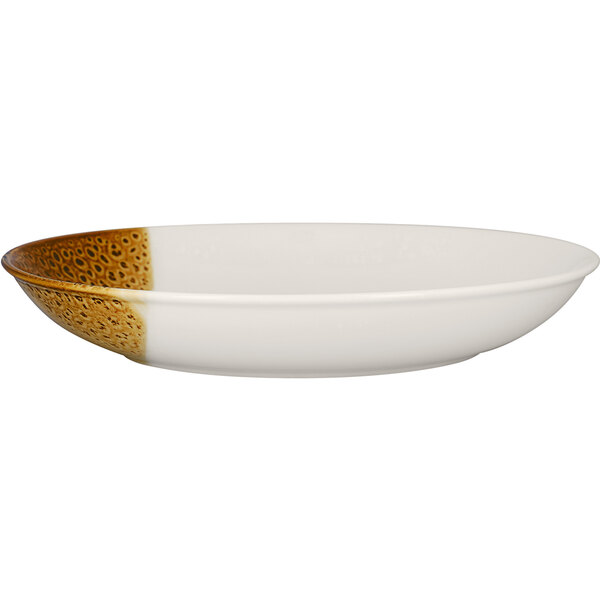 A white porcelain deep coupe plate with brown speckles on it.
