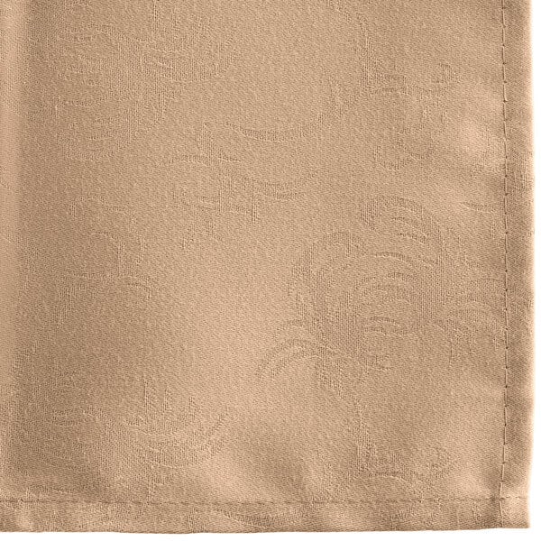 A close-up of a Snap Drape Windsor Damask Sandalwood cloth napkin with a floral design.