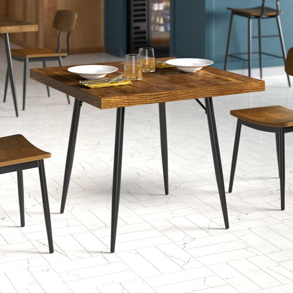 A Lancaster Table and Seating butcher block table with plates and glasses on it.