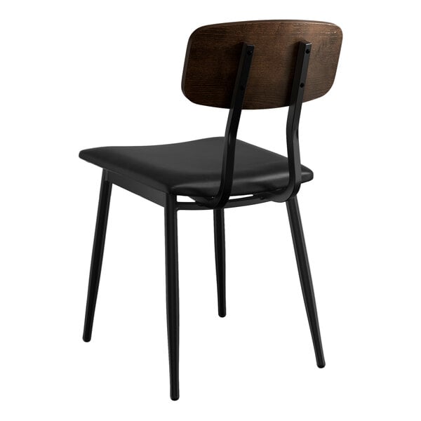 A Lancaster Table & Seating mid-century black wood chair with a black vinyl padded seat and espresso wood backrest.