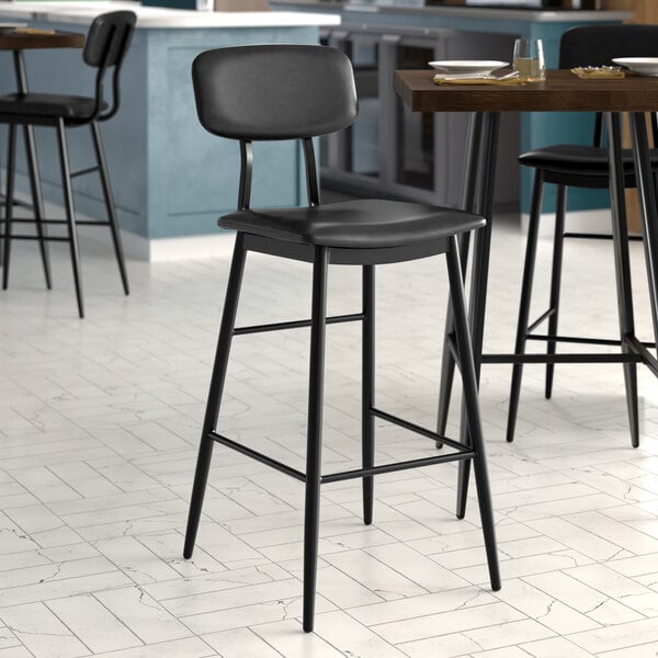 A Lancaster Table & Seating black barstool with black vinyl seat and backrest.