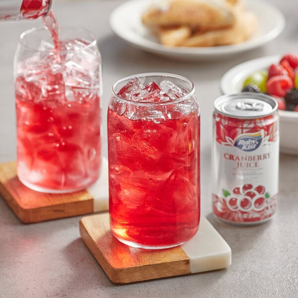 A glass of Ruby Kist cranberry juice cocktail with ice and a straw.