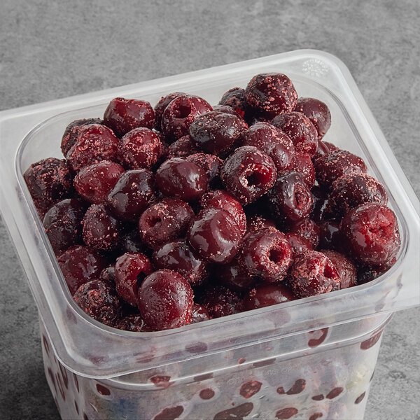 A container of IQF organic pitted dark sweet cherries.