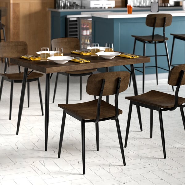 A Lancaster Table & Seating rectangular butcher block table with chairs in a dining room.