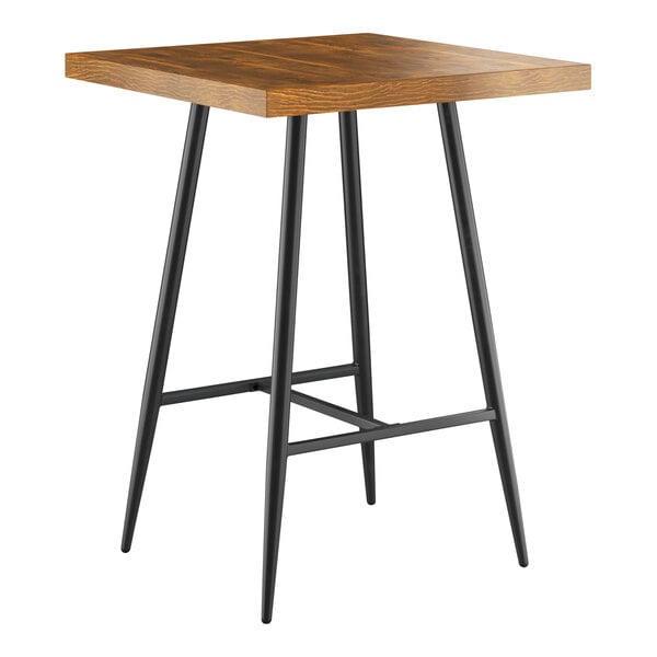 A Lancaster Table & Seating Mid-Century bar table with a wooden top and black metal legs.
