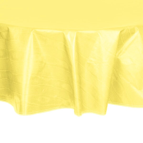 A yellow round vinyl table cover on a white table.