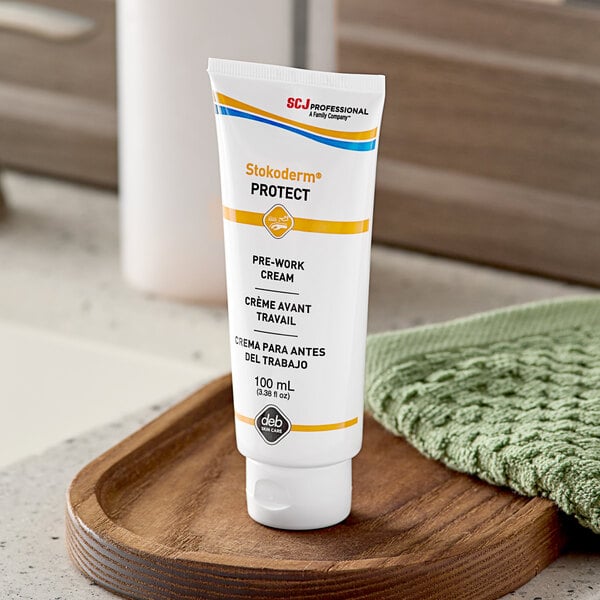 A white tube of SC Johnson Professional Stokoderm Protect hand cream with orange and blue text.