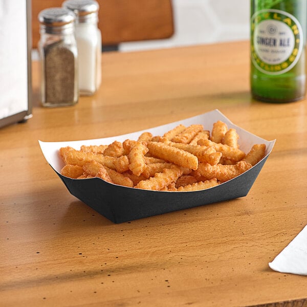 A #300 solid black paper food tray of fries on a table.