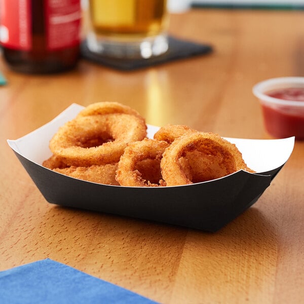 A black paper food tray holding fried onion rings.