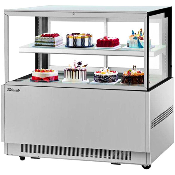 A Turbo Air refrigerated bakery display case with cakes on it.