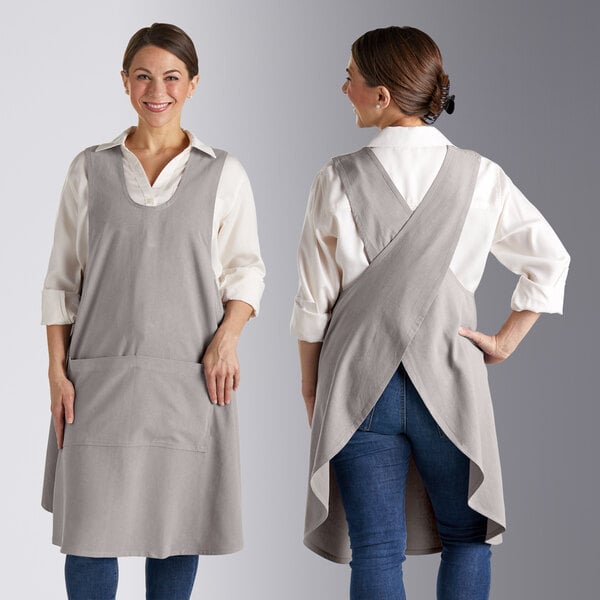 Two women wearing Acopa Ashville smock bib aprons over jeans.