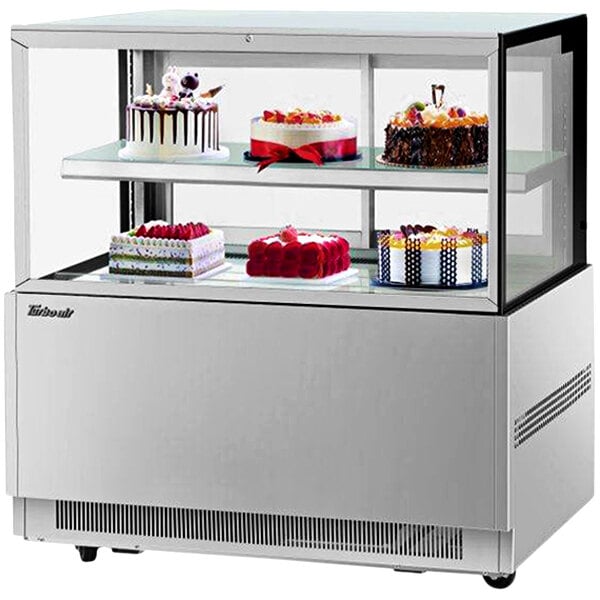 A Turbo Air refrigerated bakery display case with cakes on it.