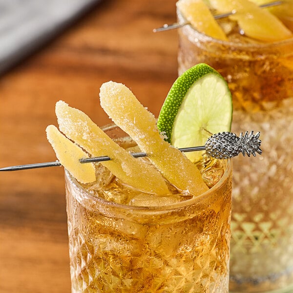 A glass of liquid with ice and orange peels.