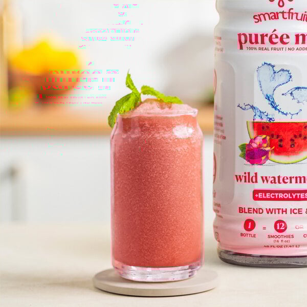 A glass of pink Smartfruit Wild Watermelon beverage on a white background.