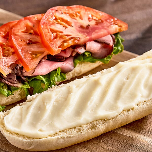 A sandwich with tomatoes and lettuce on white bread.