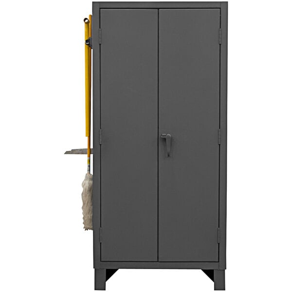 A gray Durham steel storage cabinet with 4 drawers and a door handle with a mop and broom inside.