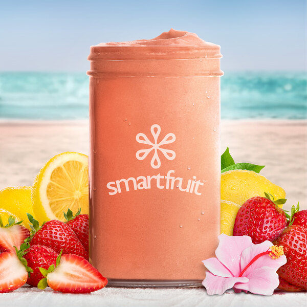 A pink smoothie made with Smartfruit Lemon Blush Puree, strawberries, and lemons.