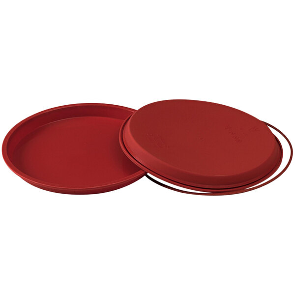 A red round silicone pizza pan with a metal handle.
