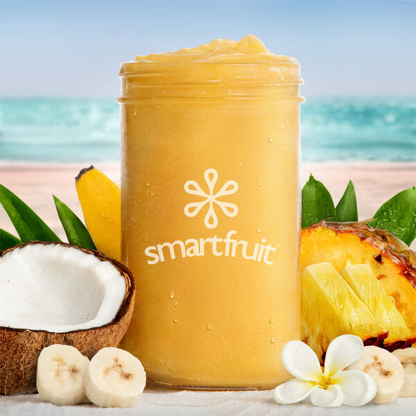 A jar of Smartfruit Aloha Pineapple smoothie with tropical fruit and flowers.
