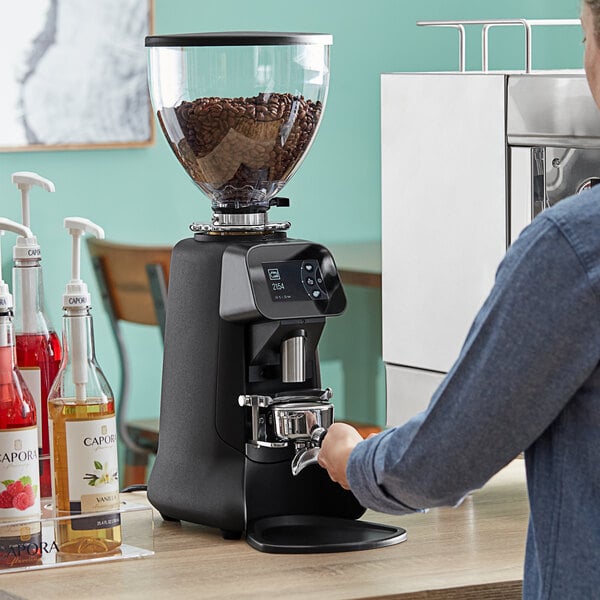 A person using a HeyCafe on-demand espresso grinder.