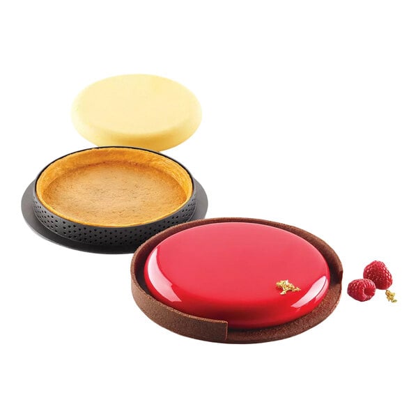 A round silicone baking mold kit with a tart ring, shown with a finished tart and raspberries.