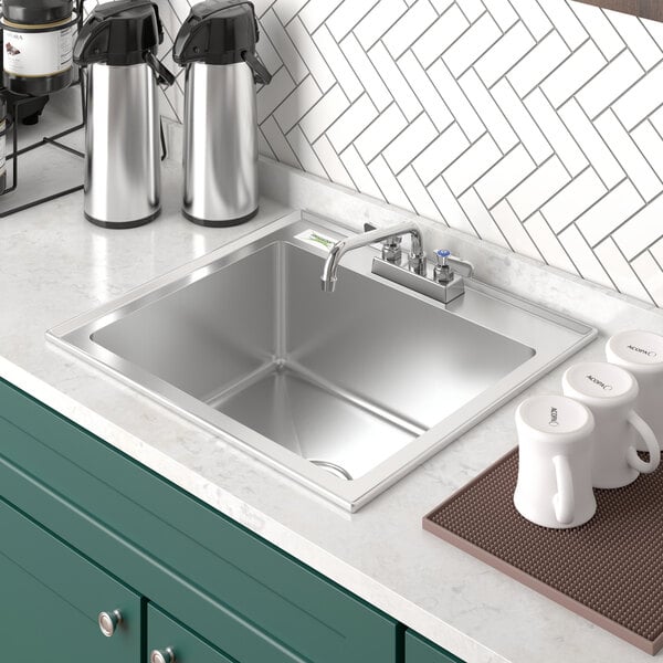 A stainless steel Regency sink with a white coffee mug in it.