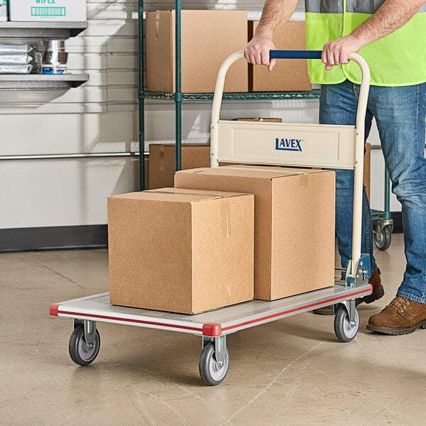 A man pushing a Lavex aluminum platform truck with boxes.