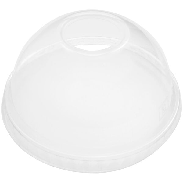 A clear plastic dome lid on a white surface with a hole.