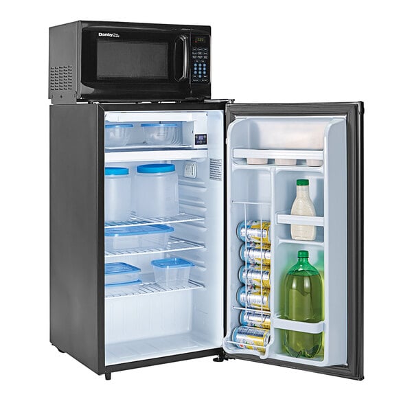 A black Danby reach-in refrigerator with a black door open and plastic containers and a green bottle inside.