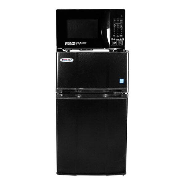 A black two-door refrigerator and freezer unit with a microwave on top.
