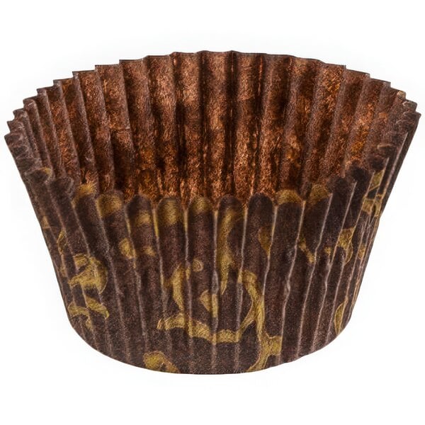 A close up of a brown paper cupcake liner with gold designs.