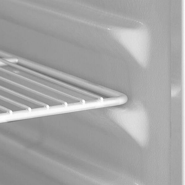 A white shelf in a Delfield reach-in refrigerator.