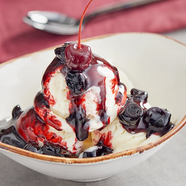A bowl of ice cream with Oringer Wild Cherry dessert topping and a cherry.
