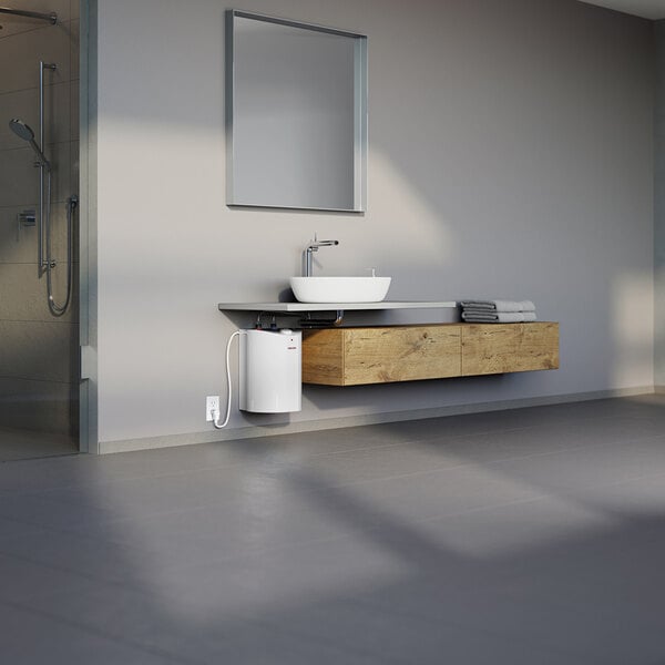 A white 6-gallon mini-tank electric water heater installed under a modern bathroom sink.