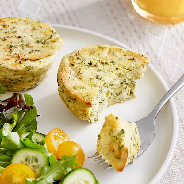 A plate with two pieces of Oak Stove Kitchens Spinach and Cheese Crustless Quiche and a fork.