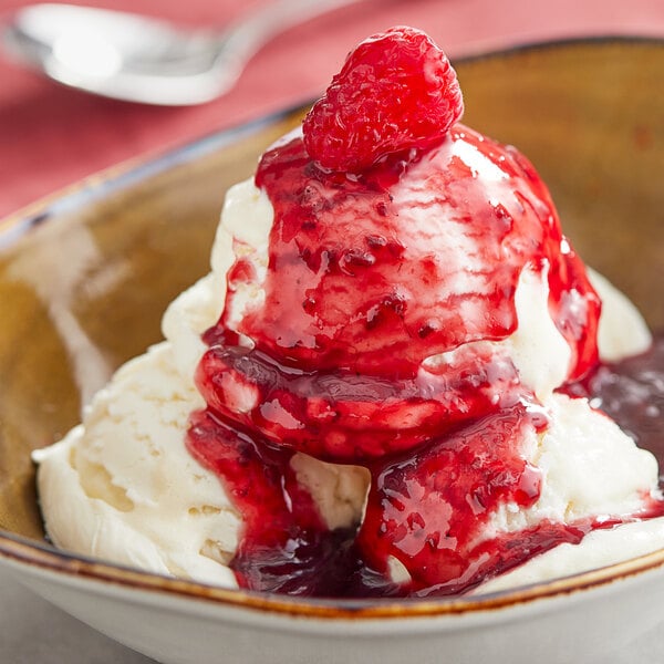 A bowl of ice cream topped with Oringer raspberry sauce.