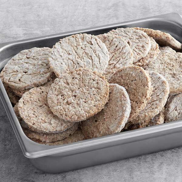 A white tray of Impossible Foods plant-based sausage patties.