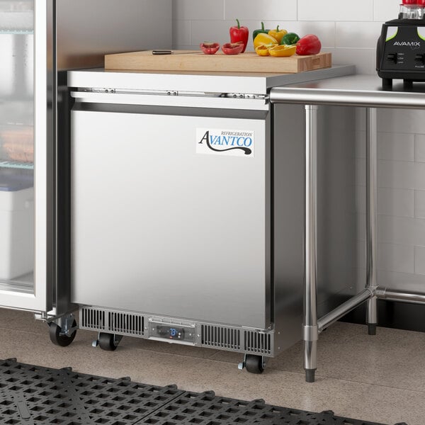 An Avantco stainless steel undercounter freezer with a cutting board on top.