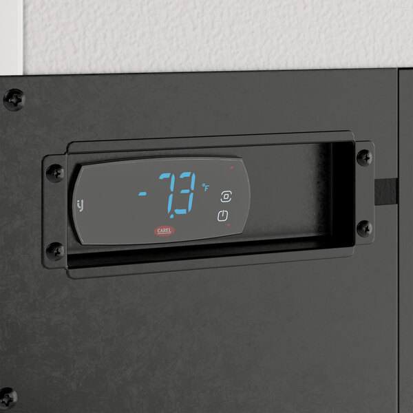 A black rectangular digital temperature control panel on a wall.