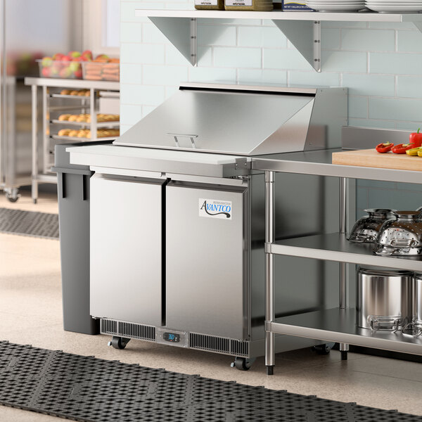 An Avantco 36" VersaHub refrigerated sandwich prep table on a stainless steel counter in a commercial kitchen.