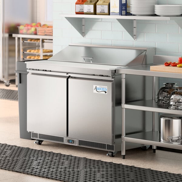 An Avantco stainless steel cutting top refrigerated prep table.